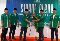 H Abdul Kharis Ma'mun menyerahkan bendera Ansor kepada H Habibi