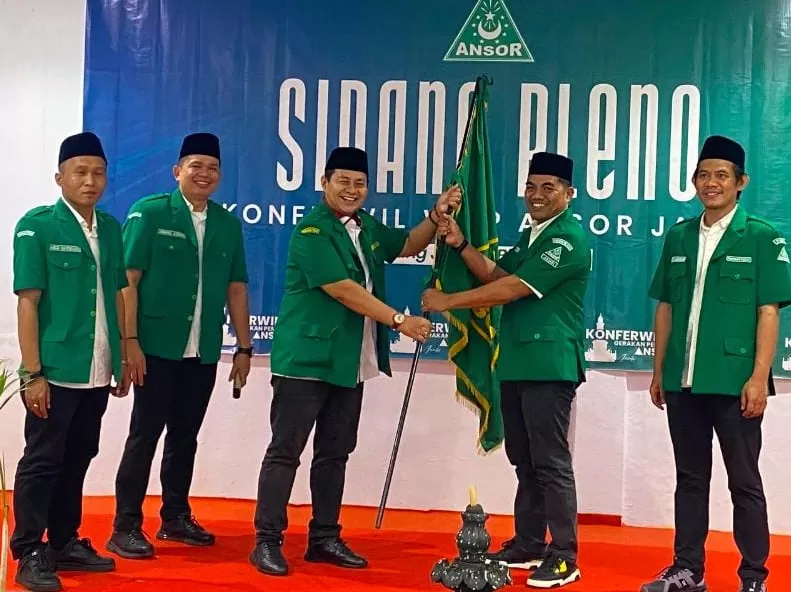 H Abdul Kharis Ma'mun menyerahkan bendera Ansor kepada H Habibi